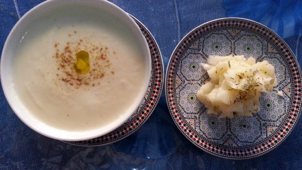 Bol con crema de coliflor al estilo andalusí y plato con coliflor preparada para acompañar la crema.
