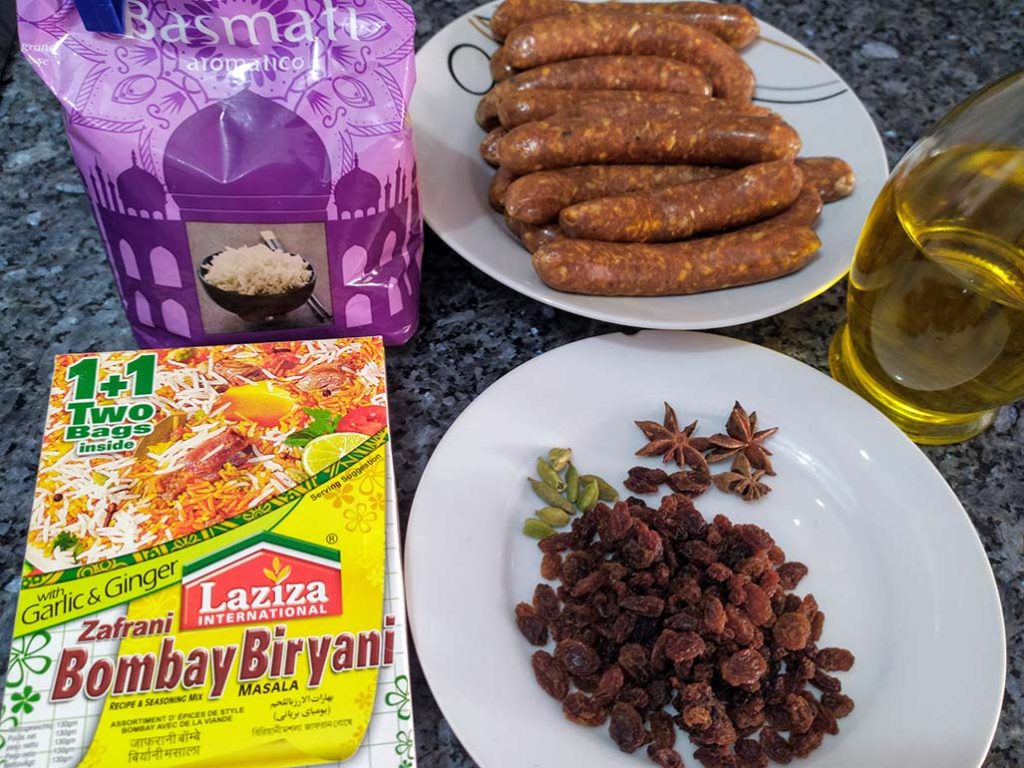 Especias para biryani: pasas, cardamomo y anís estrellado; arróz basmati; merguez de cordero y aceite de oliva virgen extra.