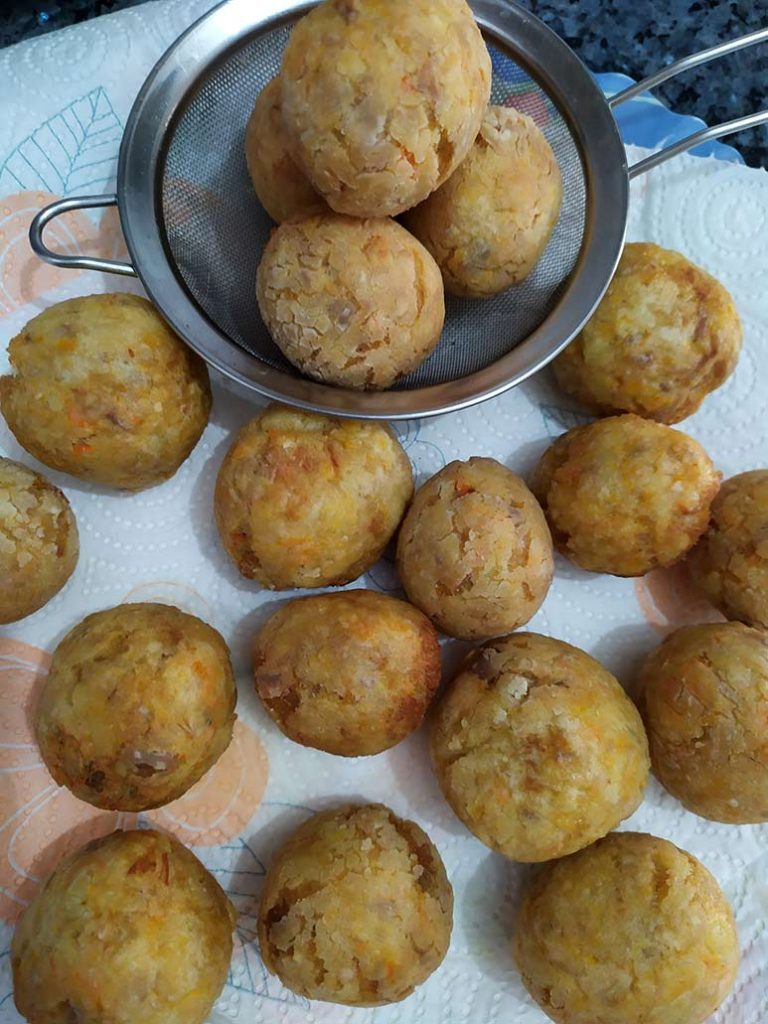 Freímos y escurrimos las albóndigas hechas con el pollo y las verduras del caldo.