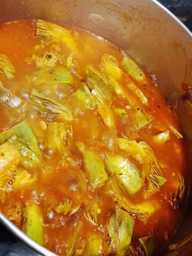 Elaborando un guiso de Alcachofas de Benicarló con patatas tomates y piñones.